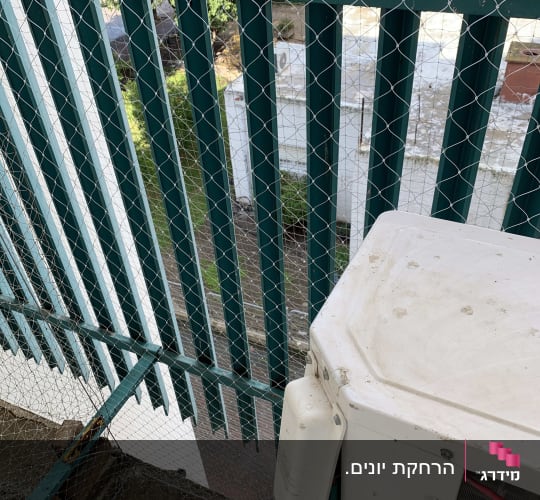 רשת מתכת מותקנת על גדר למניעת כניסת יונים
